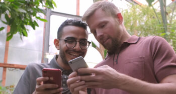 Due ragazzi usano lo smartphone e ricevono un messaggio da messenger