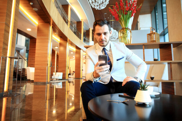 Membro dello staff dell'hotel comunica con gli ospiti da una app per smartphone.