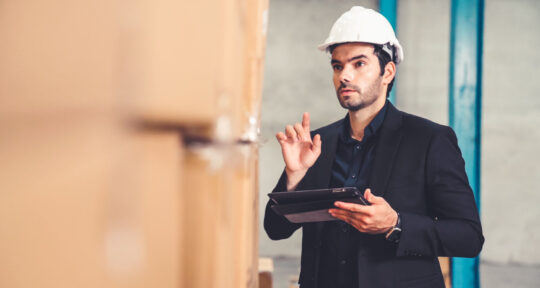 Manager della logistica guarda un tablet.