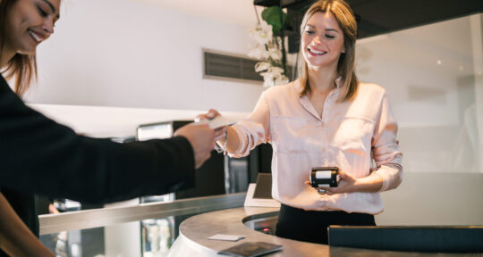 Receptionist utilizza sistemi di pagamento digitali in hotel